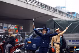 Lực lượng Thanh tra giao thông, cảnh sát giao thông hướng dẫn các phương tiện đi theo đúng tuyến đường. (Ảnh: Huy Hùng/TTXVN)