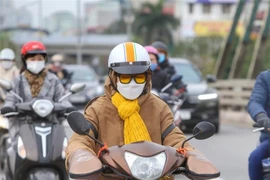 Trời rét đậm, người dân trang bị đầy đủ áo, khăn chống rét và găng tay khi ra đường. (Ảnh: Tuấn Đức/TTXVN)