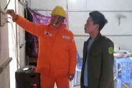 Ngay sau khi đóng điện, cán bộ công ty Điện lực Mường Tè, thuộc Công ty Điện lực Lai Châu hướng dẫn người dân cách sử dụng điện. (Ảnh: TTXVN phát)