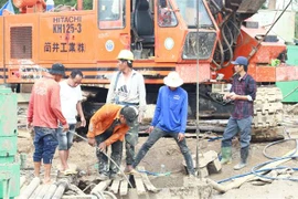 Lực lượng chức năng vẫn nỗ lực đưa thi thể em Thái Lý Hạo Nam ra khỏi cọc bêtông. (Ảnh: TTXVN phát)