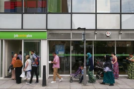 Người dân xếp hàng bên ngoài một trung tâm giới thiệu việc làm ở London, Anh. (Ảnh: AFP/TTXVN)