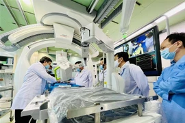 Các bác sỹ Bệnh viện Đột quỵ-Tim mạch Cần Thơ thao tác chụp DSA với sự hỗ trợ của Robot Corindus. (Ảnh: Ánh Tuyết/TTXVN)