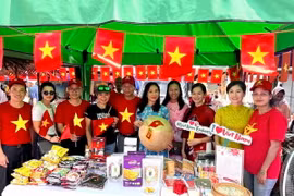 Cán bộ nhân viên Đại sứ quán và cộng đồng người Việt Nam tham gia phục vụ gian hàng lưu niệm và phở tại Lễ hội. (Ảnh: TTXVN phát)