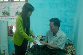 Bà Bùi Thị Quỳnh Vân trao tiền hỗ trợ cho ngư dân Lộc. (Ảnh: Sỹ Thắng/Vietnam+)