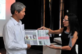 Tổng thư ký OSPAAL Lourdes Cervantes Vasquez (phải) trao tặng một poster về quan hệ song phương cho Đại sứ Việt Nam Dương Minh. (Ảnh: Lê Hà/TTXVN)