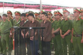 Các bị cáo đứng trước vành móng ngựa tại phiên tòa. (Ảnh: K GỬIH/TTXVN)