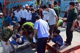 Cơ quan điều tra huyện Bình Đại khám nghiệm tử thi. (Ảnh: Trần Thị Thu Hiền/TTXVN) 