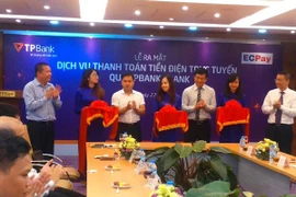Lãnh đạo hai bên ra mắt dịch vụ thanh toán tiền điện trực tuyến qua TPBank eBank. (Ảnh: CTV/Vietnam+)