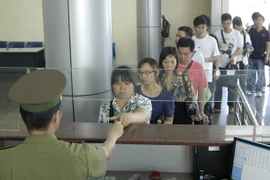 Làm thủ tục xuất, nhập cảnh qua cửa khẩu Móng Cái. (Ảnh: Minh Đông/TTXVN)