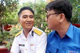 Thượng úy Hiệp gặp đại diện Ban tuyên giáo Trung ương Đoàn, đang trong chuyến thăm và làm việc tại đảo Nam Yết. (Ảnh: Văn Đức/TTXVN)