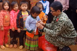 Trao áo ấm cho trẻ em vùng cao. (Nguồn: TTXVN)