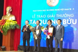 Phó Thủ tướng Vũ Đức Đam, Bộ trưởng Bộ KHCN Chu Ngọc Anh trao giải cho hai nhà khoa học xuất sắc. (Ảnh: T.H/Vietnam+