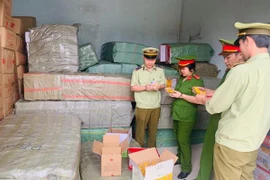 Lực lượng chức năng đang kiểm tra số bánh kẹo và đồ chơi thu được. (Nguồn: baothanhhoa.vn)