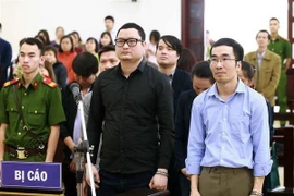 Bị cáo Trần Hữu Tiệp (áo đen) và các bị cáo khác trong vụ án thao túng giá chứng khoán. (Ảnh: Doãn Tấn/TTXVN)