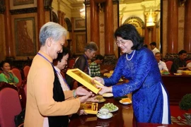 Phó Chủ tịch nước Đặng Thị Ngọc Thịnh tặng biểu trưng ảnh chân dung Bác Hồ cho các đại biểu. (Ảnh: Dương Giang/TTXVN)