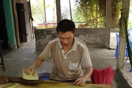 Người thợ miệt mài se hương (Ảnh: PV/Vietnam+)