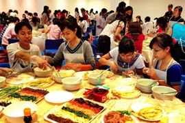 Các bạn trẻ Việt Nam tham gia làm các món ăn Hàn Quốc. (Ảnh: Thanh Hà/TTXVN)