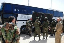 Binh sỹ Nga và Syria giám sát việc sơ tán của lực lượng nổi dậy và gia đình tại Đông Ghouta ngày 29/3. (Nguồn: THX/TTXVN)