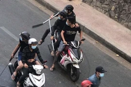 Hàng chục thanh niên chạy xe máy dùng mã tấu, dao hỗn chiến trên đường phố. (Ảnh: TTXVN phát)