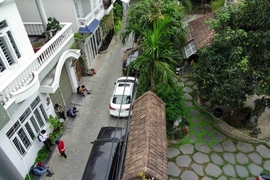 Phóng viên các báo đài và cảnh sát đứng trước của nhà ông Trần Văn Minh tại số K25/10 đường Lý Thường Kiệt. (Ảnh: Trần Lê Lâm/TTXVN)