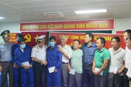 Chuẩn đô đốc Ngô Văn Thuân và lãnh đạo các cơ quan tìm kiếm cứu nạn và địa phương động viên tinh thần các ngư dân gặp nạn đã trở về đất liền an toàn. (Ảnh: Phan Sáu/TTXVN)