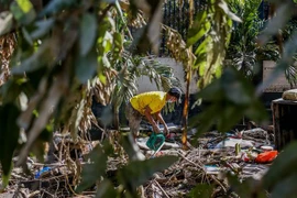 Người dân dọn đống đổ nát sau bão Vamco tại Manila, Philippines. (Ảnh: THX/TTXVN)
