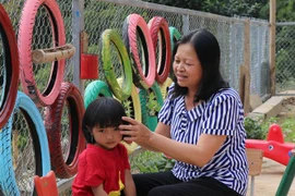 Cô giáo Lê Thị Loan chăm sóc, chải tóc cho học sinh của mình. (Ảnh: Xuân Tiến/TTXVN)