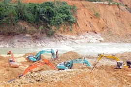 ác máy xúc đang tích cực hoạt động để tìm kiếm 12 công nhân bị mất tích tại Thủy điện Rào Trăng 3. (Ảnh: TTXVN phát)