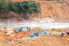 ác máy xúc đang tích cực hoạt động để tìm kiếm 12 công nhân bị mất tích tại Thủy điện Rào Trăng 3. (Ảnh: TTXVN phát)