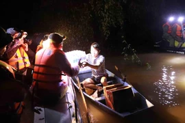 Cứu trợ nhu yếu phẩm cho người dân bị cô lập do mưa lũ. (Ảnh: Vũ Sinh/TTXVN)