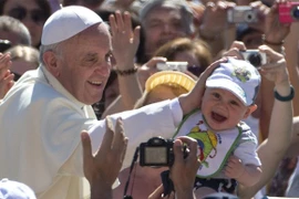 Giáo hoàng Francis cho một cậu bé tại Vatican (Nguồn: Telegraph)