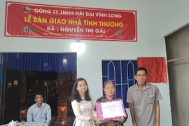 Đoàn thanh niên Thông Tấn Xã Việt Nam tặng quà cho gia đình có nhà mới tại huyện Ba Tri, Bến Tre. (Ảnh: Huỳnh Phúc Hậu/TTXVN)