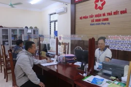 Người dân đến làm thủ tục hành chính tại bộ phận một cửa xã Nghi Long (Nghi Lộc, Nghệ An). (Ảnh: Bích Huệ/TTXVN)