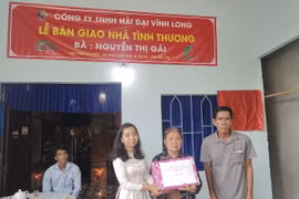 Đoàn thanh niên Thông Tấn Xã Việt Nam tặng quà cho gia đình có nhà mới tại huyện Ba Tri, Bến Tre. (Ảnh: Huỳnh Phúc Hậu/TTXVN)