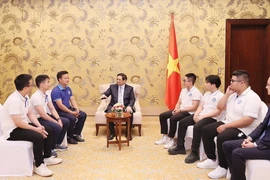 Thủ tướng Phạm Minh Chính chúc mừng các sinh viên xuất sắc giành giải thưởng tại COP28. (Ảnh: Dương Giang/TTXVN)