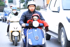Người dân ra đường đều trang bị cho mình quần áo ấm, quấn khăn, đeo khẩu trang… để chống lại thời tiết lạnh buốt. (Ảnh: Quang Quyết/TTXVN)