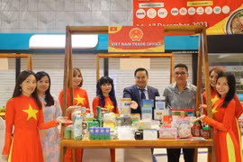 Tham tán Thương mại Lê Phú Cường (thứ tư từ bên phải) và ông Wong Hon Wai - Giám đốc Điều hành, phụ trách lĩnh vực du lịch và kinh tế sáng tạo của Penang (thứ ba từ bên phải) cùng kiều bào tại quầy hàng giới thiệu sản phẩm của Thương vụ Việt Nam tại Malaysia. (Ảnh: Hằng Linh/TTXVN)