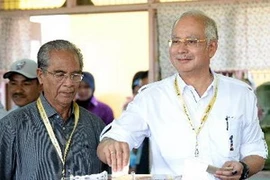 Thủ tướng Malaysia Najib Razak (phải) bỏ phiếu tại điểm bầu cử ở thị trấn quê nhà Pekan ngày 5/5. (Ảnh: AFP/TTXVN)