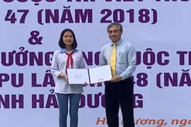 Thứ trưởng Bộ Thông tin và Truyền thông Nguyễn Minh Hồng trao giải ba quốc tế Cuộc thi Viết thư quốc tế UPU 47 - năm 2018 cho em Nguyễn Thị Bạch Dương, học sinh Trường THCS Nguyễn Trãi, huyện Nam Sách. (Ảnh: Hiền Anh/TTXVN)