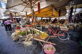 Người dân mua sắm tại một khu chợ ở Rome của Italy. (Ảnh: AFP/TTXVN)