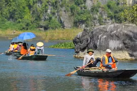 Chèo đò bằng chân đưa khách du lịch quốc tế đi tham quan tại khu du lịch Tam Cốc. (Ảnh: Minh Đức/TTXVN) 