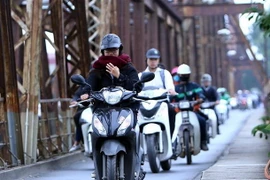 Người dân với trang phục áo ấm đi trên cầu Long Biên của Hà Nội. (Ảnh: Danh Lam/TTXVN)