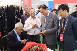 Đại sứ Việt Nam Phạm Sanh Châu và các đại biểu tham quan các gian hàng. (Ảnh: Huy Lê/TTXVN)