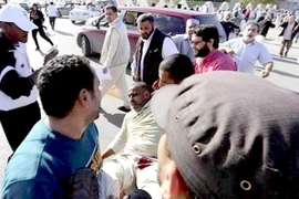 Một người bị thương được người dân đưa ra khỏi hiện trường vụ đấu súng ở Tripoli, 15/11. (Nguồn: Reuters)