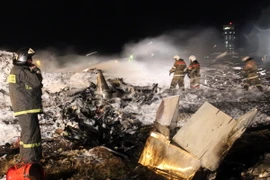 Nhân viên cứu hỏa làm nhiệm vụ tại hiện trường vụ tai nạn. (Nguồn: AFP/TTXVN)