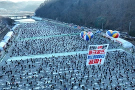 Du khách tham gia lễ hội câu cá trên băng Hwacheon Sancheoneo, Hàn Quốc. (Ảnh: Yonhap/TTXVN) 