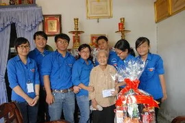 Tặng quà Mẹ Việt Nam anh hùng. (Ảnh: TTXVN)