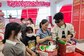 Người dân thành phố Huế sử dụng làn khi đi mua sắm tại siêu thị. (Ảnh: Tường Vi/TTXVN)