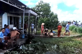 Người dân cùng chính quyền xã Tân Trung đến nhà Trần Minh Đắc giải cứu cháu bé 3 tuổi bị bạo hành. (Nguồn: Báo Thanh Niên)