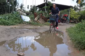 Đường trong khu dân cư đều là đường đất, lầy lội đọng nước vào mùa mưa. (Ảnh: Phạm Cường/TTXVN)
